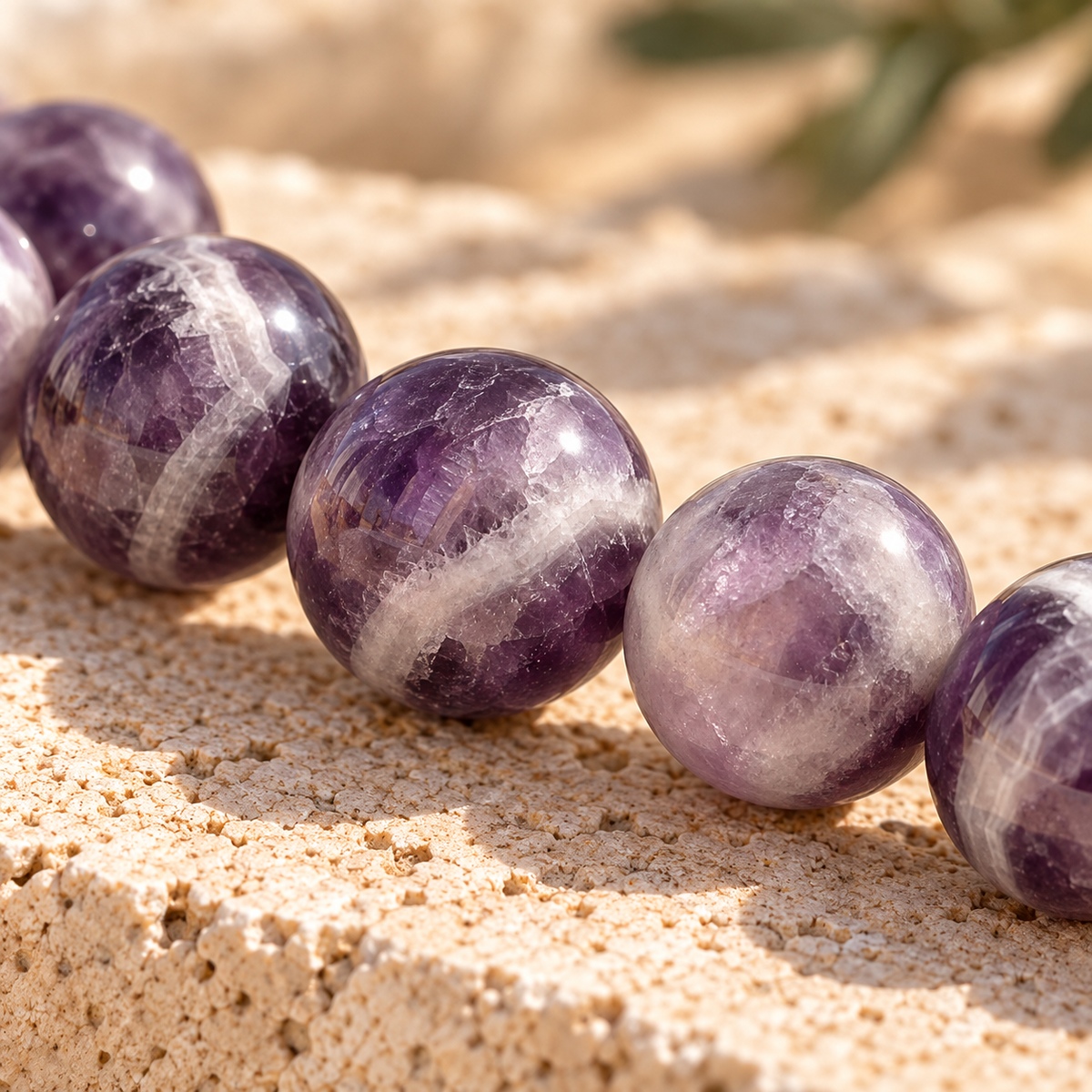 Gros plan sur les perles en améthyste naturelle, nuances violettes et veinages blancs, Atelier Sémio.