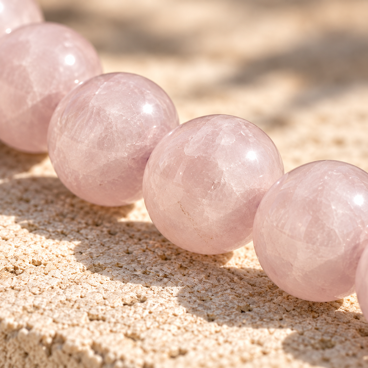 Gros plan sur les perles en quartz rose naturel, nuances rose pâle et inclusions, Atelier Sémio.